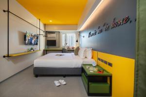 a hotel room with a bed and a table with slippers at lyf Malate Manila managed by The Ascott Limited in Manila +27 photos