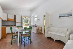 Una cocina y una sala de estar con mesa y sillas. en Appartamento La Spiga, en Procchio