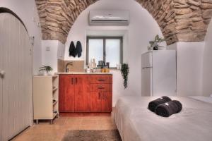 um quarto com uma cama e uma cozinha com um frigorífico em בראשית - סוויטות בוטיק בצפת העתיקה - Beresheet - Boutique Suites in the Old City em Safed