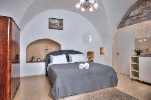 1 dormitorio con 1 cama con 2 toallas en בראשית - סוויטות בוטיק בצפת העתיקה - Beresheet - Boutique Suites in the Old City en Safed