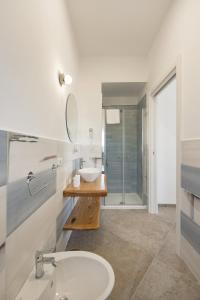 a white bathroom with a sink and a mirror at Villa Caterina b&b in Procida