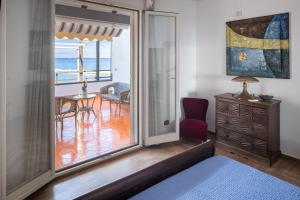 チーニジにあるVero Sicily - Villa San Giorgioの海の景色を望むガラスのスライドドアが備わる客室です。