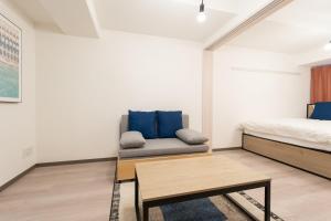 um quarto com uma cama, um sofá e uma mesa em Casa Blan em Tóquio