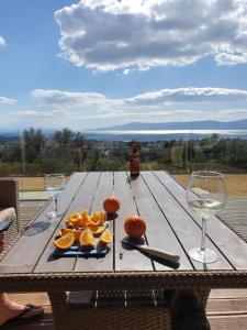 a wooden table with oranges and wine glasses on it at Willa wakacyjna z basenem w Eretria in Eretria