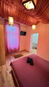 リヴィウにある31 Kotliarska MoishaHouseのベッドルーム1室(紫色のベッド1台、黒い靴2本付)
