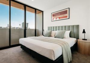 a bedroom with a large bed and a large window at Rambla at Perry House in Brisbane