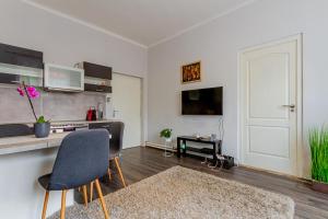 a white living room with a table and a chair at Pannónia Szentendre in Szentendre +10 photos