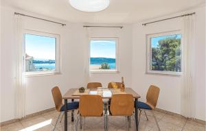 comedor con mesa, sillas y ventanas en Gorgeous Apartment In Kastel Sucurac With House Sea View, en Kaštela