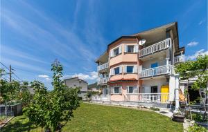 ein großes Apartmenthaus mit Rasen davor in der Unterkunft Gorgeous Apartment In Kastel Sucurac With House Sea View in Kaštela