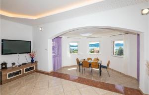 ein Esszimmer mit einem Tisch und einem TV in der Unterkunft Gorgeous Apartment In Kastel Sucurac With House Sea View in Kaštela