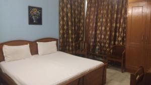 1 dormitorio pequeño con 1 cama y 2 sillas en first choice guest house pvt ltd, en Gurgaon