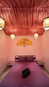 リヴィウにある31 Kotliarska MoishaHouseのベッドルーム1室(紫のシーツが敷かれた大型ベッド1台付)