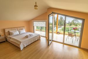 una camera da letto con un letto grande e un balcone di Nefeli & Dina Villas by Diomedes Group a Nea Moudania Altre 53 foto