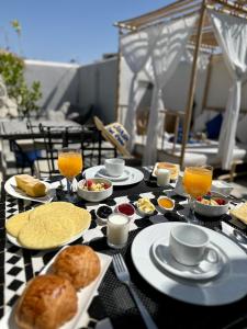 una mesa cubierta con platos de comida y bebida en Riad Jardin Des Rêves, en Marrakech
