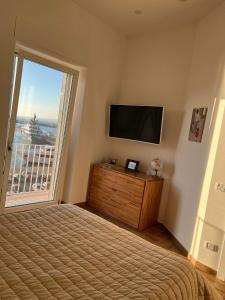 een slaapkamer met een bed, een tv en een raam bij Coralinehaven in Castellammare di Stabia