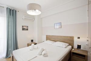 een slaapkamer met een groot wit bed en een raam bij Blue Dream in Piraeus