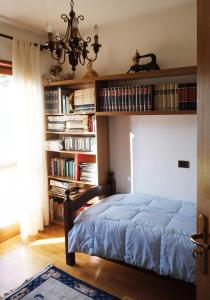 a bed in a room with bookshelves at Rose Apartment in Aosta