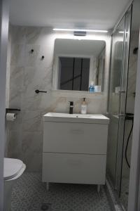a bathroom with a white sink and a mirror at Alma Sea House in Hanioti +23 photos