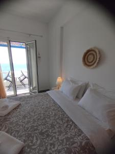 a bedroom with a bed with a view of the ocean at Marisini Sea View in Batsi