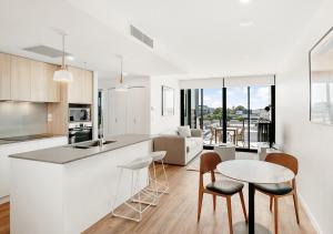 a kitchen and living room with a table and chairs at Rambla at Perry House in Brisbane