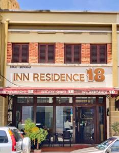 Inn Residence 18 في جورج تاون: عماره فيها لوحه مكتوب فيها مقاومه