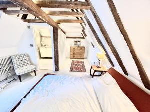 a bedroom with a bed and a chair at Petworth Cottage-Sleeps 6-Pet Friendly-Central in Petworth