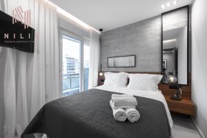 a bedroom with a large bed with towels on it at Hermes Suites, Agia Sofia, Nilie Hospitality MGMT in Thessaloniki
