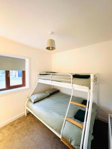 a bedroom with two bunk beds and a window at Robins Cottage 