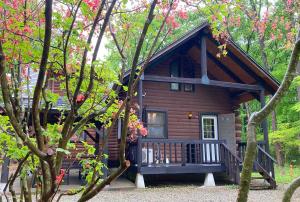 a log cabin in the woods with pink flowers at COTTAGE SaY in Nasushiobara