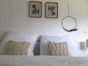 1 cama blanca con 2 almohadas y espejo en la pared en Berghaus 2 komfortable Wohnungen für bis zu 7 Personen - Familie - Wandern - E-Bike - Hunde - E-Ladesäule - WiFi, en Schmallenberg