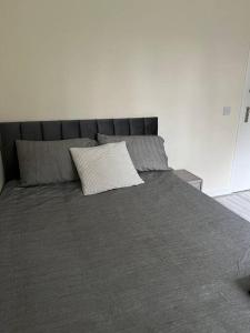 a large gray bed with a pillow on it at Extra Large House in Woolwich in Plumstead