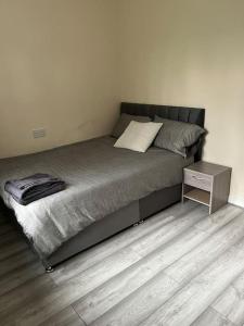 a bedroom with a bed with a night stand on it at Extra Large House in Woolwich in Plumstead