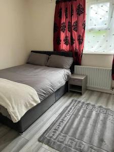 a bedroom with a bed and a window and a rug at Extra Large House in Woolwich in Plumstead