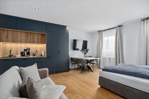 a bedroom with a bed and a kitchen with a table at ANYTIME - Rohrbach Apartments in Friedrichshafen