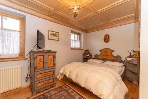a bedroom with a bed and a television in it at Casa Soreje in Mazzin