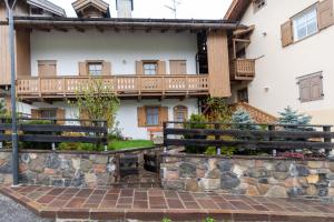 a house with a balcony and a stone wall at Casa Soreje in Mazzin
