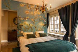 1 dormitorio con 1 cama con pared de flores en Place to Bee (Kamers) en Kortrijk