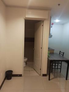 um quarto com um WC, uma mesa e uma porta em WJV INN LAHUG em Cebu