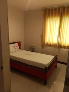 1 dormitorio con 1 cama en una habitación con ventana en WJV INN LAHUG en Cebú