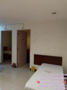 1 dormitorio con 1 cama y 1 dormitorio con puerta en WJV INN LAHUG en Cebu City