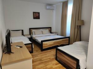 Habitación de hotel con 2 camas y escritorio en FENIX Gevgelija, en Gevgelija