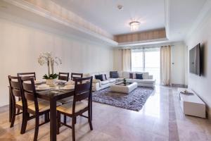 een woonkamer met een eettafel en een bank bij Bespoke Holiday Homes - Palm Jumeirah- 1 Bedroom Fairmont North Residence in Dubai