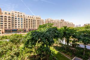 een uitzicht op een gebouw met bomen ervoor bij Bespoke Holiday Homes - Palm Jumeirah- 1 Bedroom Fairmont North Residence in Dubai