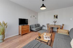 a living room with a couch and a table at Downtown Apartments Seaside Awiator in Gdańsk