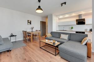 a living room with a couch and a table at Downtown Apartments Seaside Awiator in Gdańsk
