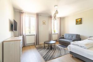 ein Wohnzimmer mit einem Bett und einem Sofa in der Unterkunft Victus Apartamenty, Apartament Chopin 2 in Sopot