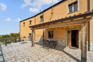 um pátio com uma mesa e cadeiras ao lado de um edifício em Villa Mariuccia em Dolianova