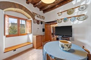 une salle à manger avec une table et une télévision dans l'établissement Villa Mariuccia, à Dolianova