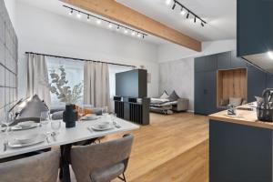eine Küche und ein Wohnzimmer mit Tisch und Stühlen in der Unterkunft ANYTIME - Rohrbach Apartments in Friedrichshafen + 37 Fotos