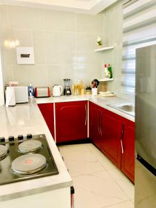 a kitchen with red cabinets and a stove top oven at Monaco villa Palapye in Palatswe